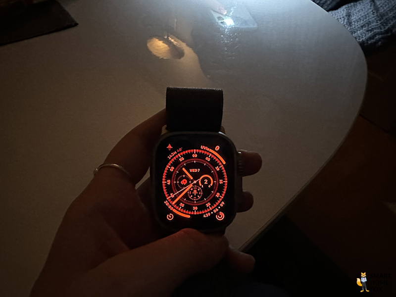 Man sieht den Nachtmodus des Wegweiser-Ziffernblattes auf der Apple Watch Ultra.